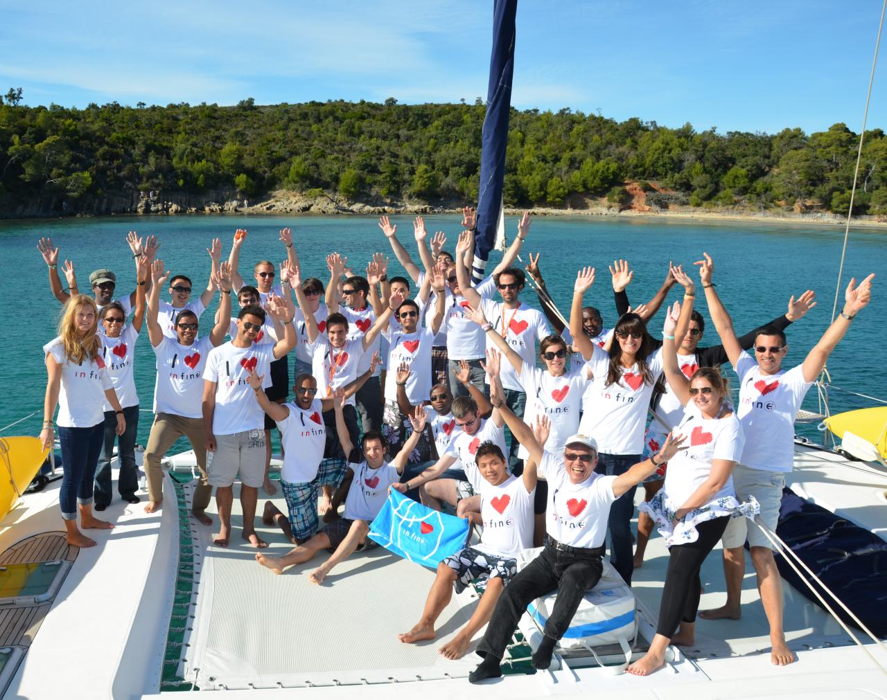 Les consultants in finē réunis sur un bateau, portant des tee-shirts aux couleurs de l’entreprise